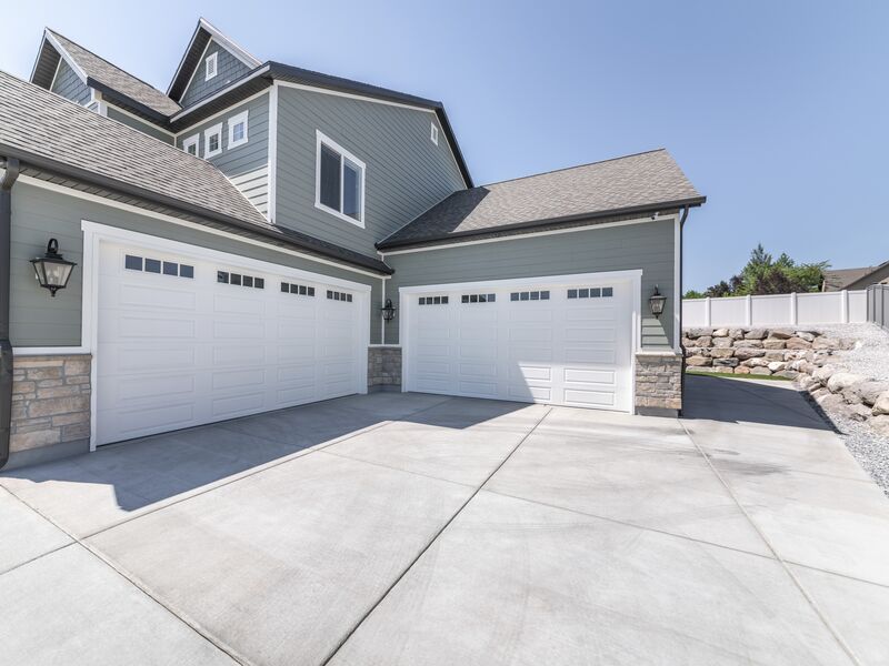 White overhead doors with window panels on twin garages of two-story family home